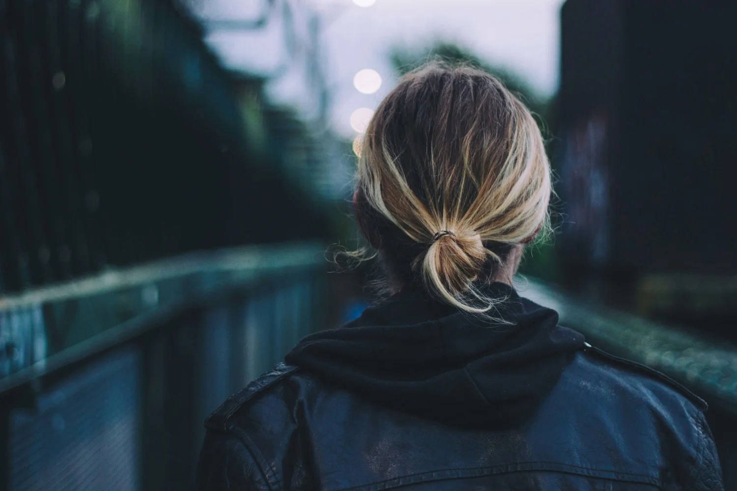 A woman seen from behind in a dark, atmospheric setting